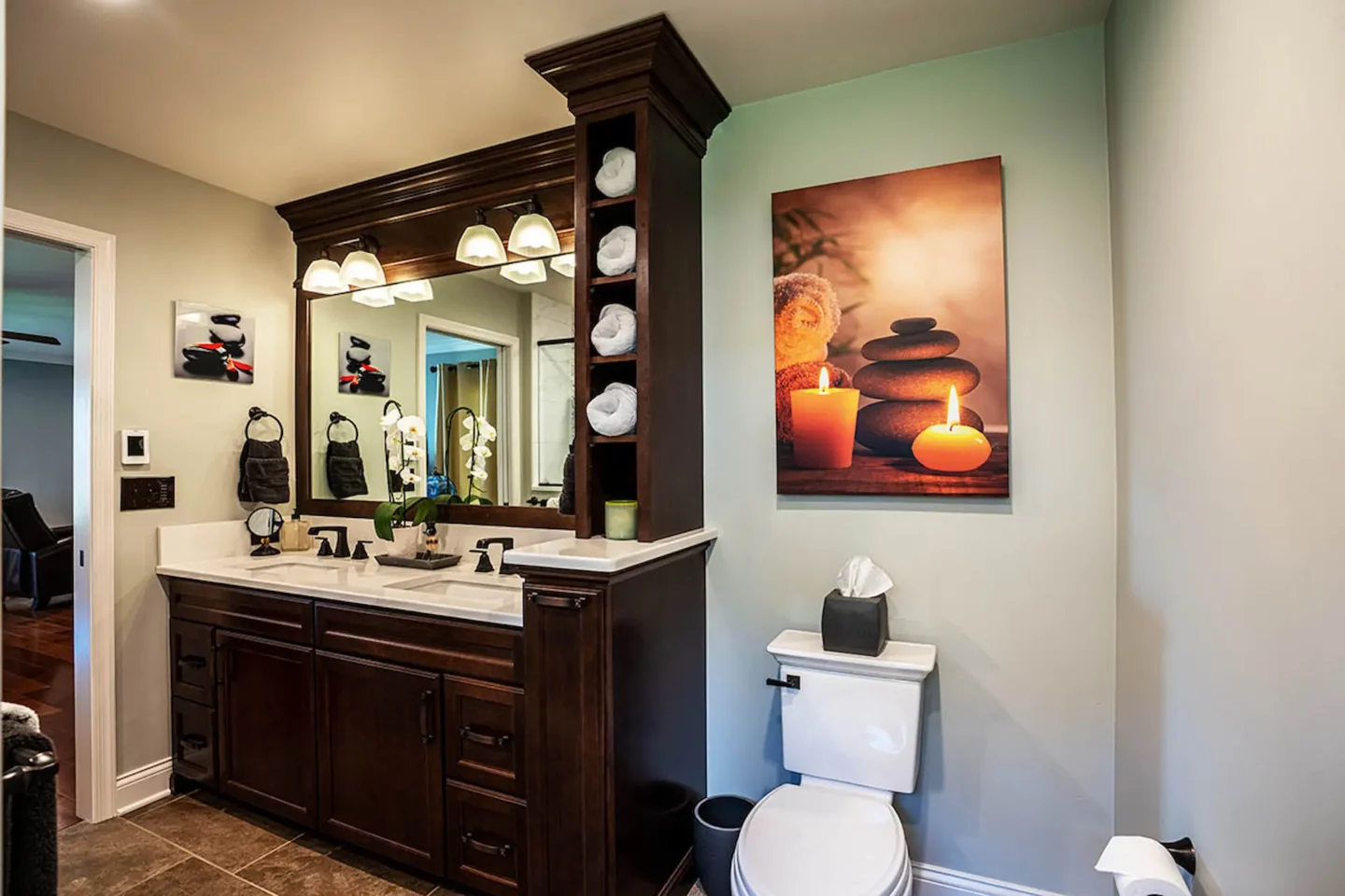 Double sink vanity with open storage for towels in North Wales bathroom