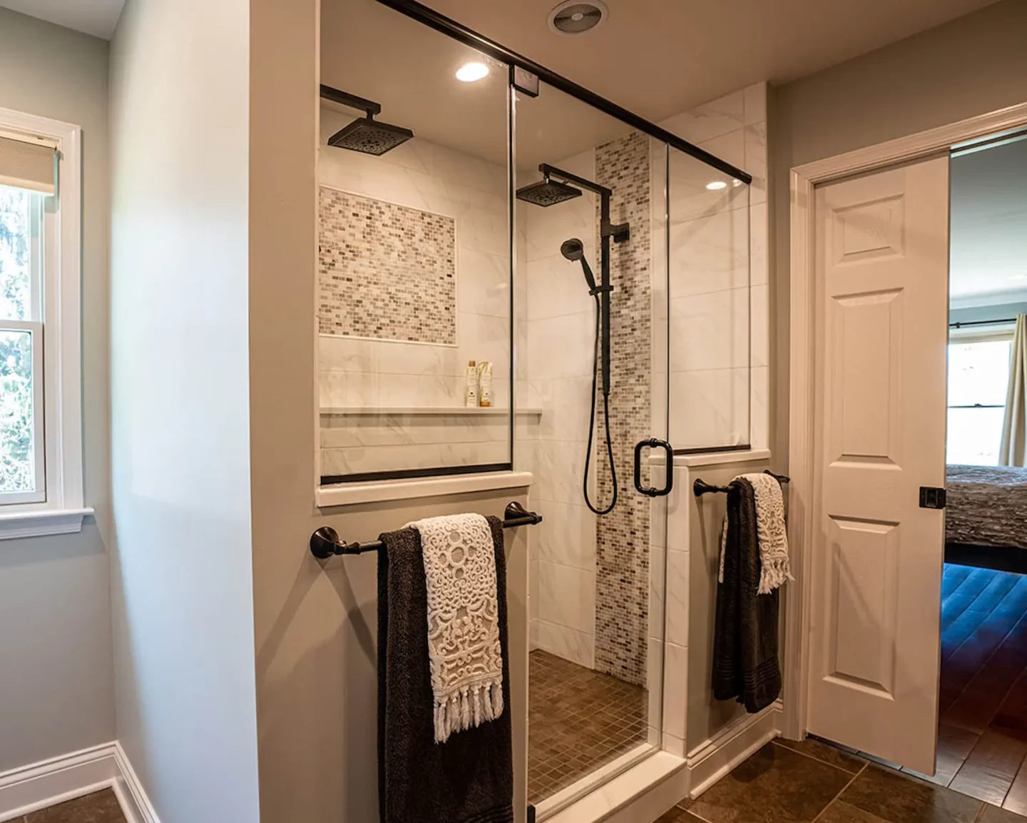 Glass enclosed shower area with two towel hangers in North Wales bathroom -2