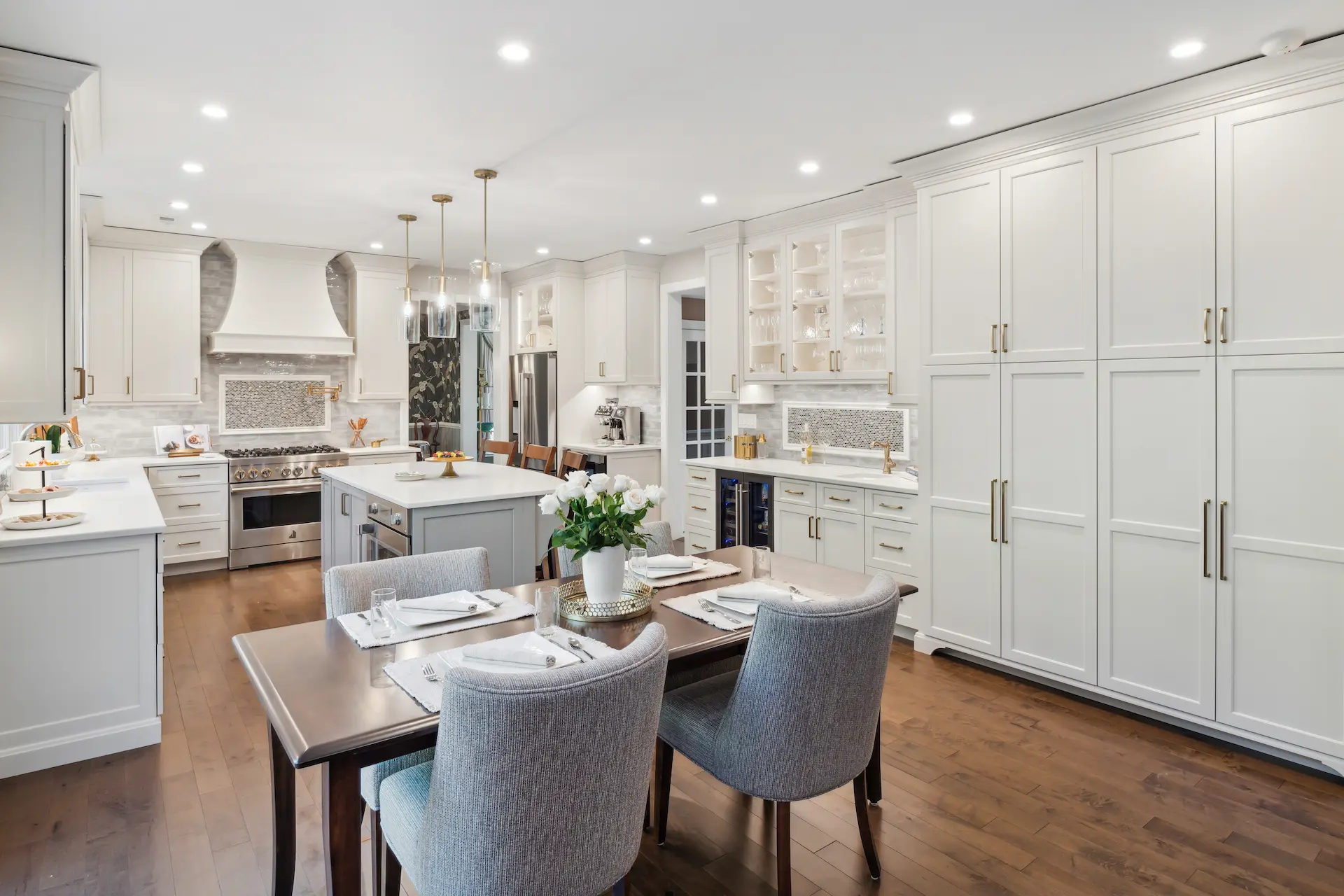 White kitchen with decorative hood beverage station coffee bar large island.