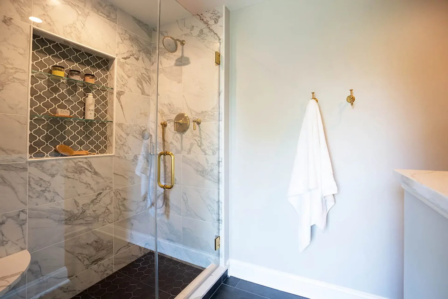 Enclosed Glass Shower Room With Towel Holders Pinned to the Wall