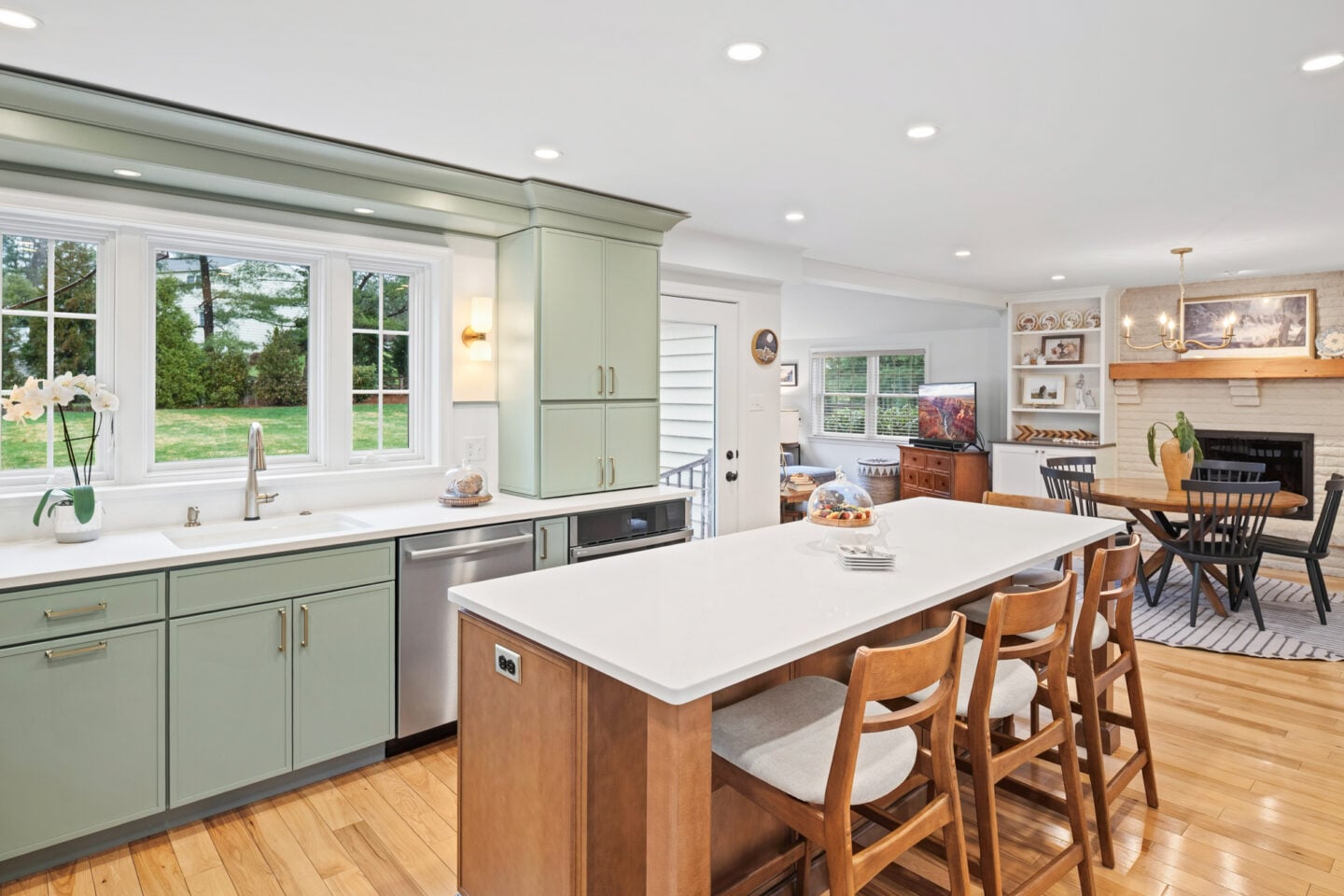 Open kitchen with fireplace and seating area connecting to adjacent living space