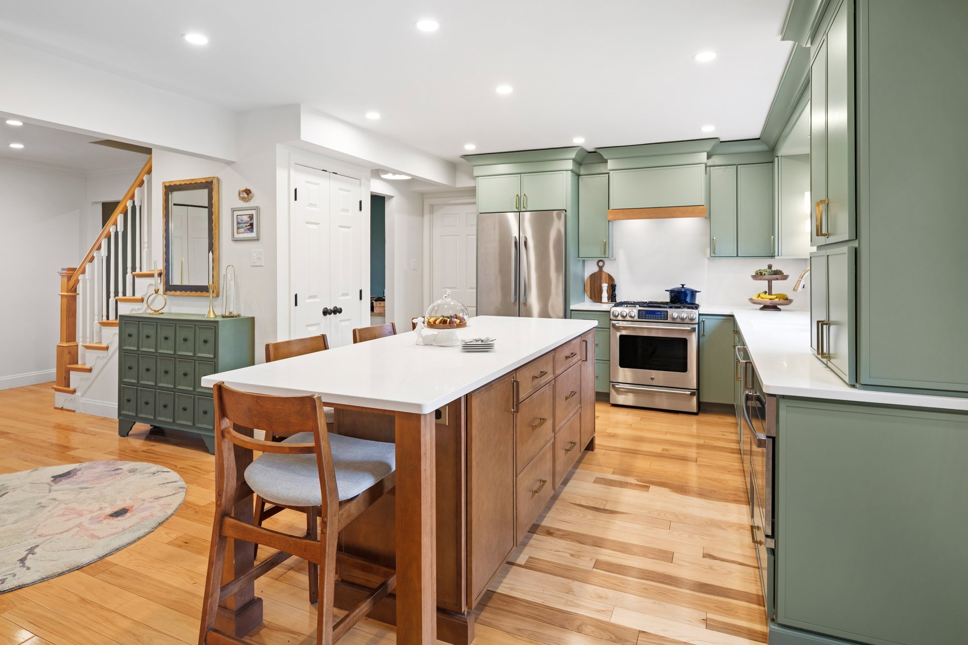 Painted kitchen cabinets paired with stained wood island and light countertops