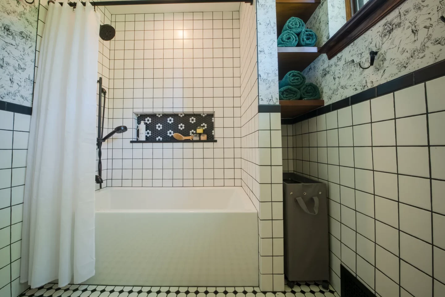 Classic hall bathroom with white wall tile, black trim, and timeless black-and-white flooring
