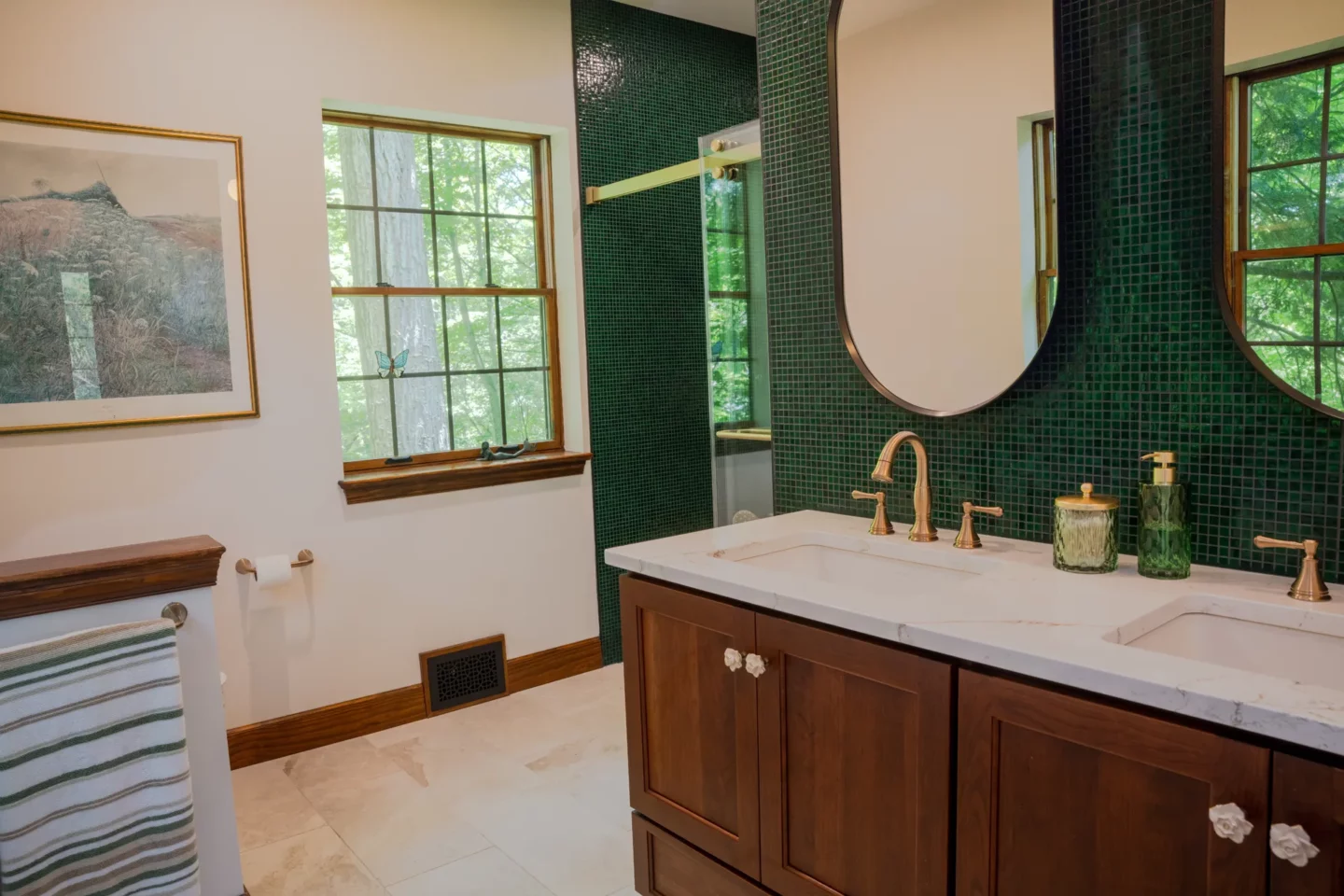 Custom cherry vanity with champagne bronze fixtures in a luxury primary bathroom remodel.