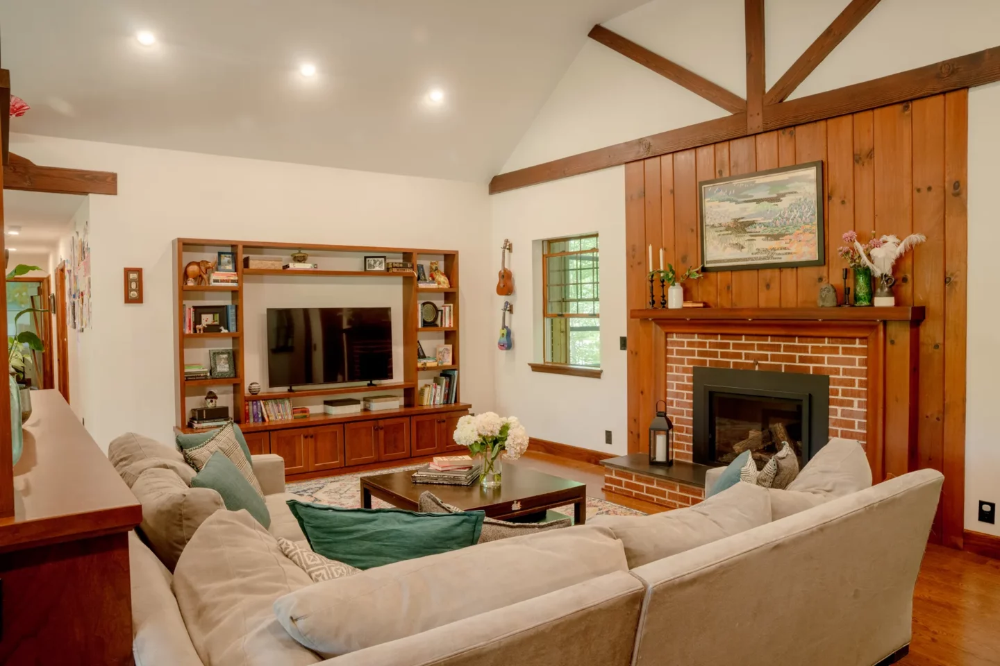 Living room with custom built-in cabinetry, exposed beams, and restored architectural character.