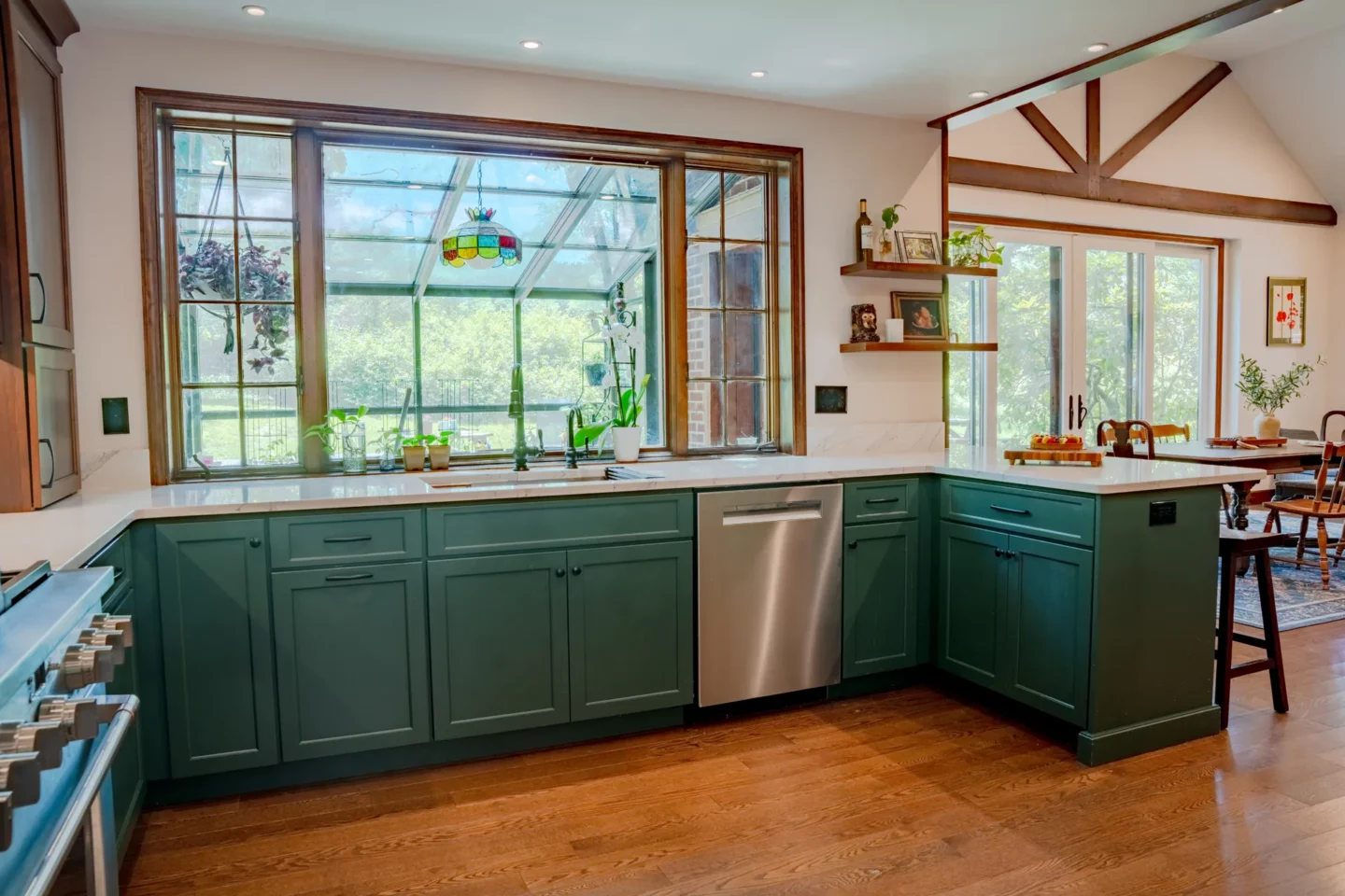 View from the living room into the remodeled kitchen with Olympic Green cabinetry and open sightlines.